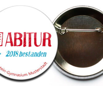 Abi Button 4 mit Sicherheitsnadel und Aufdruck des Gymnasiums