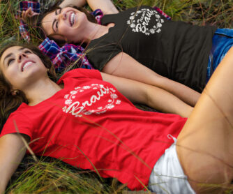 2 Frauen liegen zum JGA lachend im Gras und tragen JGA-Shirts T73