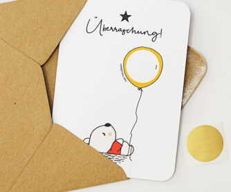 Rubbelkarte mit einem Bär, der einen Luftballon (mit beschreibbarem Rubbelfeld) hält und der Überschrift "Überraschung"